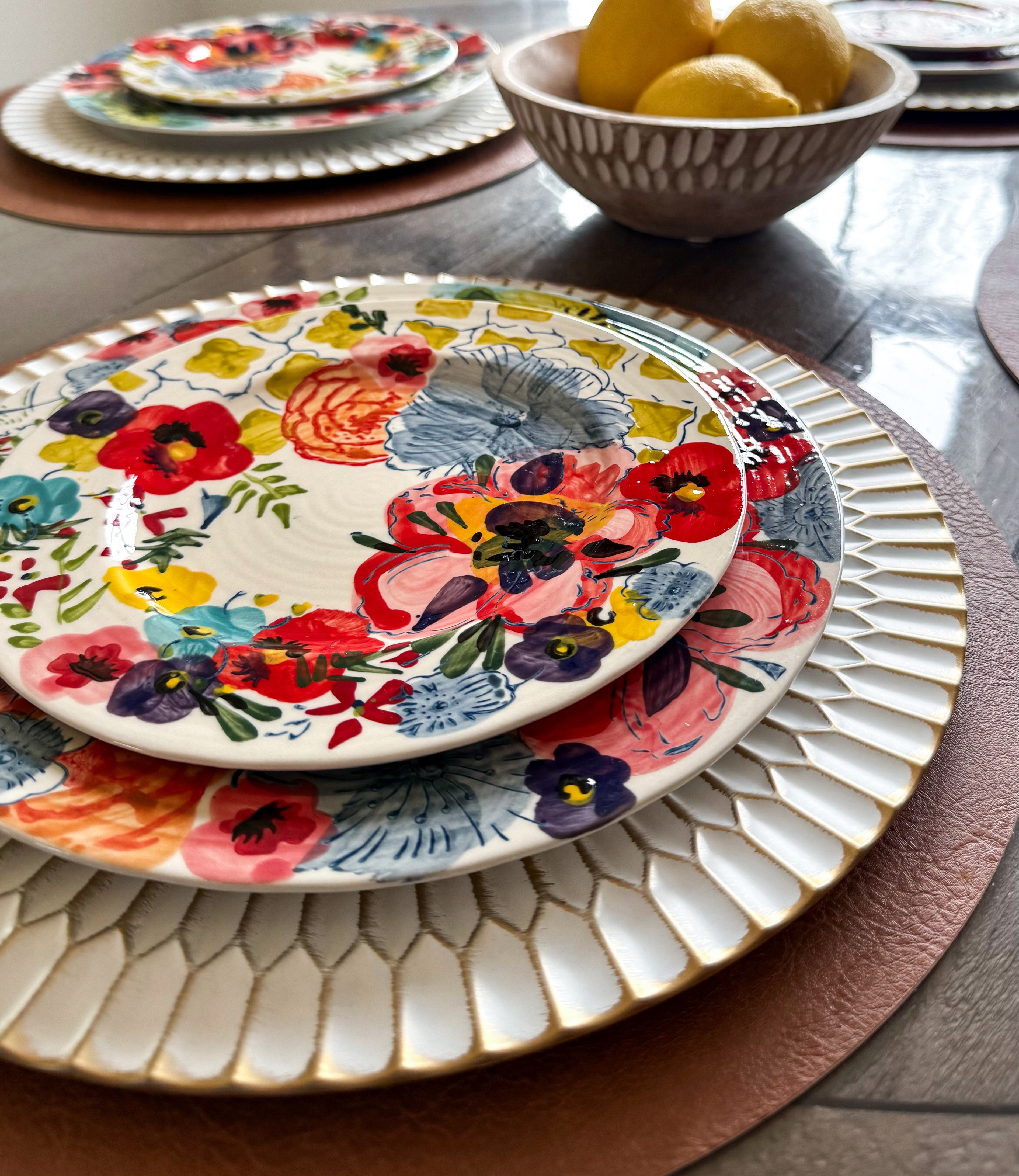 Gold charger plates with floral plates on leather placemat