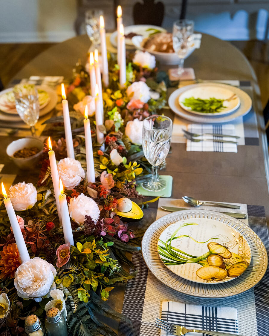 The long table in October — chargers, tapers, and the runner built that morning.