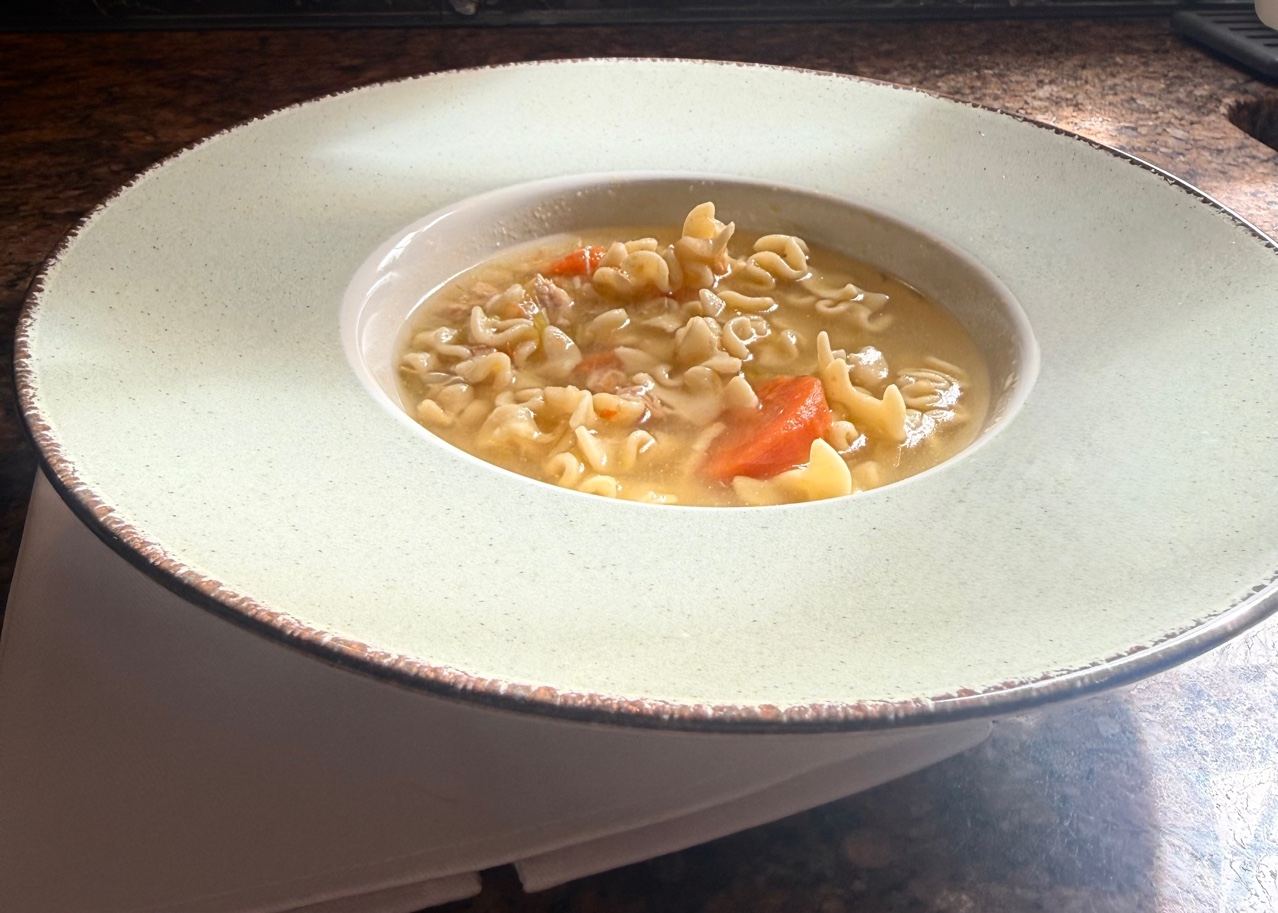 A wide-rimmed bowl of soup on the counter.