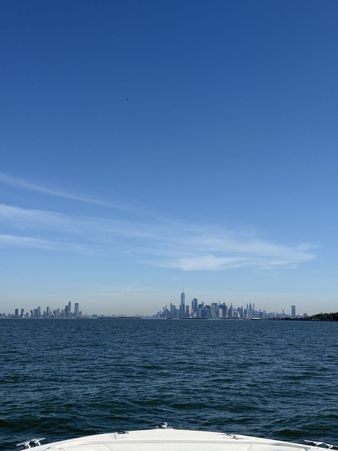 The Manhattan skyline seen in the distance from a boat on the harbor.
